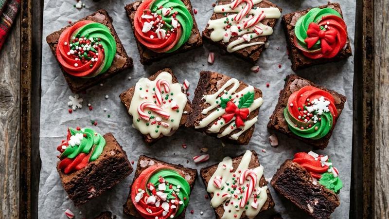 Plate of fudgy Christmas brownie bites topped with peppermint buttercream frosting and red and green holiday sprinkles