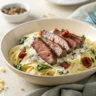 Creamy steak gorgonzola alfredo pasta with sliced steak and balsamic glaze