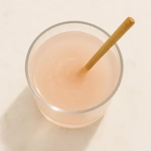 Pink Himalayan salt dissolving in a glass of water on a wooden surface